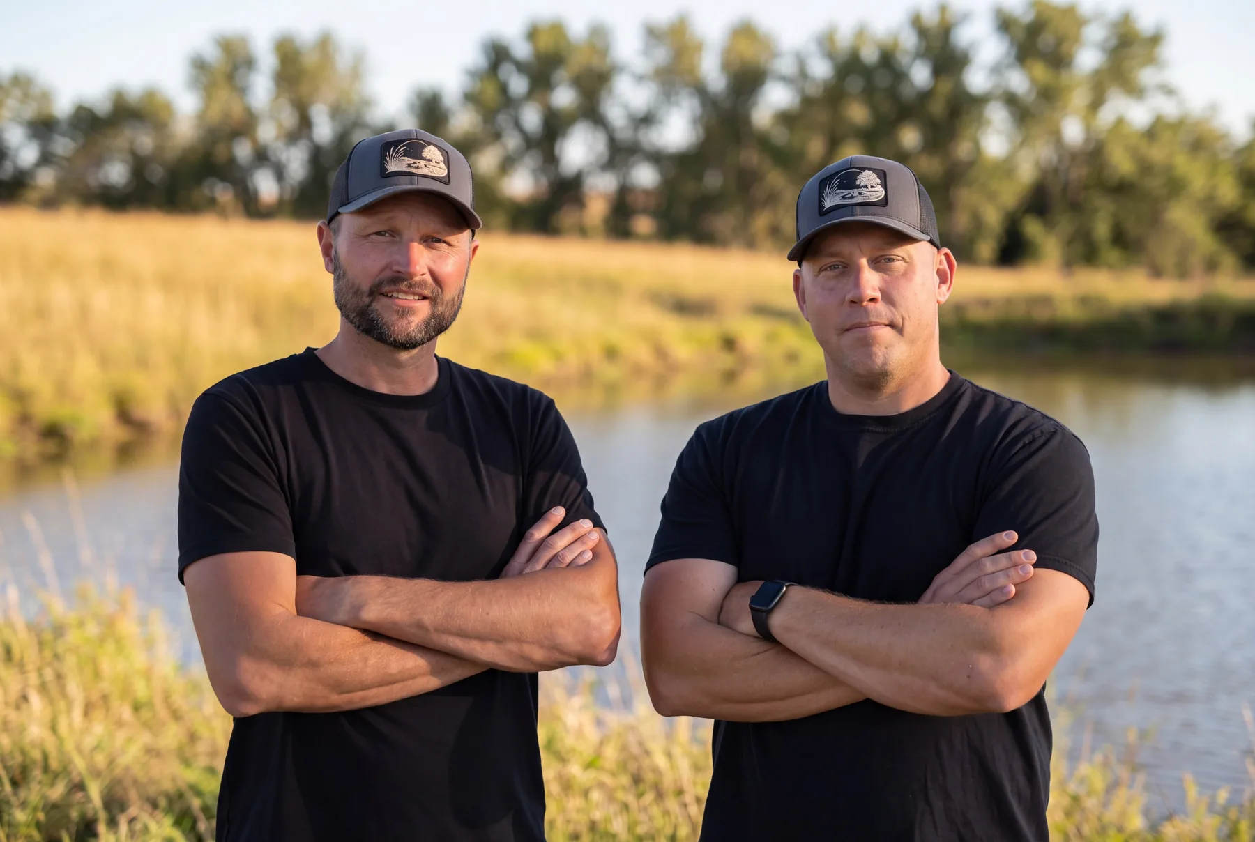 Brian Ring and Josh Muller, co-owners of Prairie Creek Land & Water, standing on the bank of a Kansas pond